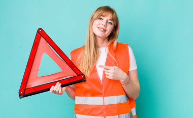 Kızıl saçlı, güzel bir kadın heyecanlı ve şaşırmış görünüyor. araba acil üçgeni