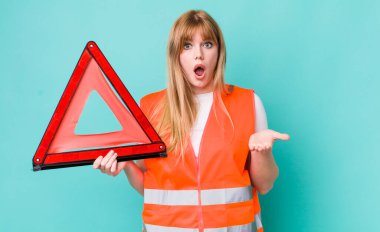 Kızıl saçlı güzel kadın inanılmaz bir sürprizle şaşkına dönmüş ve hayrete düşmüştü. araba acil üçgeni