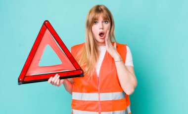 Kızıl saçlı güzel kadın şok olmuş ve korkmuş hissediyor. araba acil üçgeni