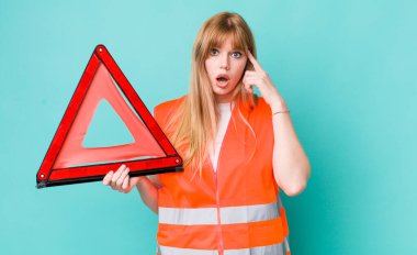 Kızıl saçlı güzel kadın şaşırmış görünüyor, yeni bir düşünce, fikir ya da konsept fark ediyor. araba acil üçgeni