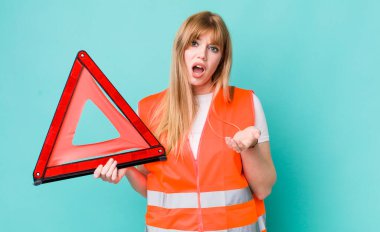 Kızıl saçlı güzel kadın umutsuz, hayal kırıklığına uğramış ve stresli görünüyor. araba acil üçgeni