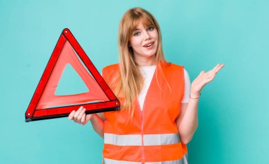 Kızıl saçlı güzel kadın kendini mutlu hissediyor, bir çözüm ya da fikir bulduğuna şaşırıyor. araba acil üçgeni