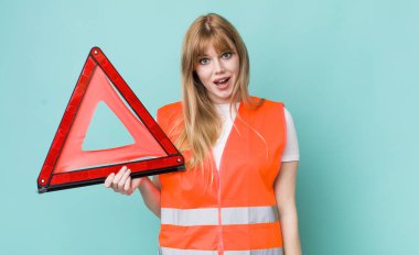 Kızıl saçlı güzel kadın mutlu ve hoş bir şekilde şaşırmış görünüyor. araba acil üçgeni