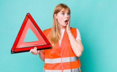 Kızıl saçlı güzel kadın mutlu, heyecanlı ve şaşırmış hissediyor. araba acil üçgeni