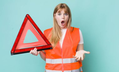 Kızıl saçlı güzel kadın çok şaşırmış ve şok olmuş hissediyor. araba acil üçgeni