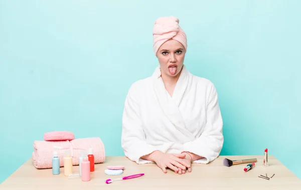 赤い頭の可愛い女はうんざりしていらいらして舌を出してる シャワーと化粧品のコンセプト — ストック写真