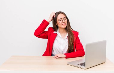 İspanyol güzel kadın şaşkın ve kafası karışık, kaşınan bir kafa hissediyor. iş ve masa konsepti