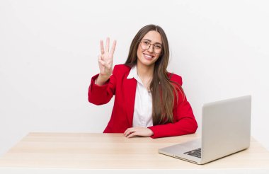 İspanyol güzel kadın gülümsüyor ve arkadaş canlısı görünüyor, üç numarayı gösteriyor. iş ve masa konsepti