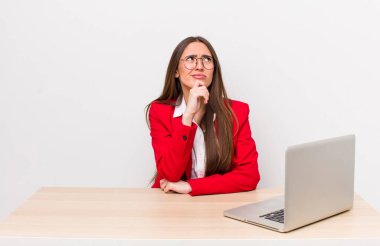 Hispanik güzel kadın düşünüyor, kuşkulu ve şaşkın hissediyor. iş ve masa konsepti