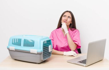 Hispanik güzel kadın düşünüyor, kuşkulu ve şaşkın hissediyor. Veterinerlik kavramı