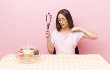 İspanyol güzel kadın stresli, endişeli, yorgun ve hayal kırıklığına uğramış hissediyor. Ev yapımı kek konsepti