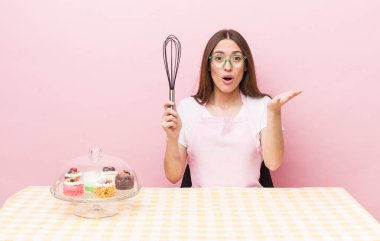 İspanyol güzel kadın son derece şaşırmış ve şok olmuş hissediyor. Ev yapımı kek konsepti