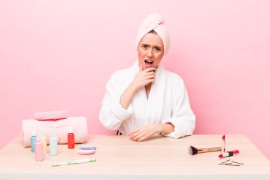 Ağzı ve gözleri açık ve eli çenesinde olan Latin kökenli güzel bir kadın. uydurma konsepti