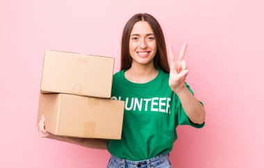 İspanyol güzel kadın gülümsüyor ve mutlu görünüyor, zafer ya da barış işareti yapıyor. gönüllülük kavramı