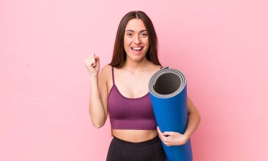 İspanyol güzel kadın şokta, gülüyor ve başarıyı kutluyor. fitness ve yoga konsepti