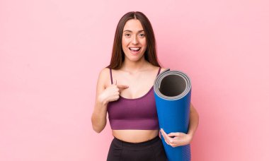 İspanyol güzel kadın kendini mutlu hissediyor ve heyecanla kendini işaret ediyor. fitness ve yoga konsepti