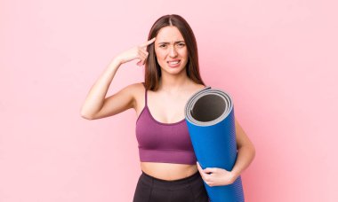 İspanyol güzel kadın kafası karışık ve şaşkın hissediyor, senin deli olduğunu gösteriyor. fitness ve yoga konsepti