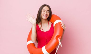 İspanyol güzel kadın mutlu bir şekilde gülümsüyor, el sallıyor, seni selamlıyor ve selamlıyor. cankurtaran konsepti