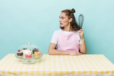 young pretty woman  on profile view thinking, imagining or daydreaming. home made cakes concept