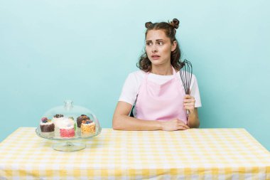 young pretty woman  feeling sad, upset or angry and looking to the side. home made cakes concept