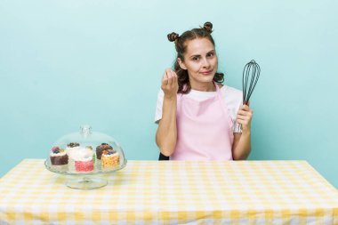 Genç ve güzel bir kadın kapiş ya da para hareketi yapıyor, sana ödemeni söylüyor. Ev yapımı kek konsepti