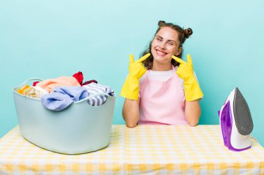 Genç ve güzel bir kadın, kendine güvenerek gülümsüyor. ev işi kavramı