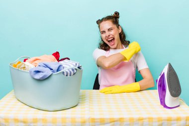 Genç ve güzel bir kadın kendini mutlu hissediyor ve bir meydan okumayla yüzleşiyor ya da kutluyor. ev işi kavramı