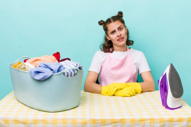 Genç ve güzel bir kadın şaşkın ve şaşkın hissediyor. ev işi kavramı