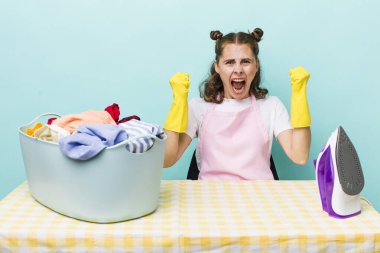 Genç ve güzel bir kadın sinirli bir ifadeyle agresif bir şekilde bağırıyor. ev işi kavramı