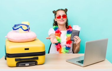 Genç ve güzel bir kadın arkadaşça gülümsüyor ve bir konsept sunuyor. seyahat kavramı