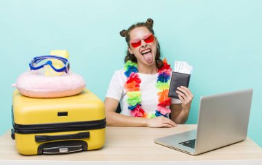 Neşeli ve asi tavırları olan genç ve güzel bir kadın, şaka yapıyor ve dilini dışarı çıkarıyor. seyahat kavramı