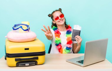 Genç, güzel bir bayan gülümsüyor ve arkadaş canlısı görünüyor, üç numarayı gösteriyor. seyahat kavramı