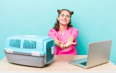 Genç ve güzel bir kadın arkadaşça gülümsüyor ve bir konsept sunuyor. Veterinerlik kavramı