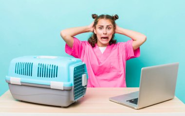 Genç ve güzel bir kadın gergin, endişeli ya da korkmuş hissediyor. Elleri başının üstünde. Veterinerlik kavramı