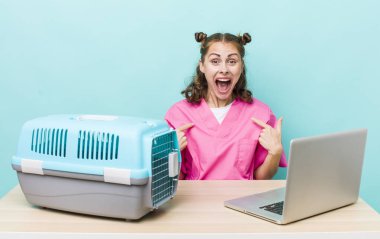 Genç ve güzel bir kadın kendini mutlu hissediyor ve heyecanlı bir şekilde kendini işaret ediyor. Veterinerlik kavramı