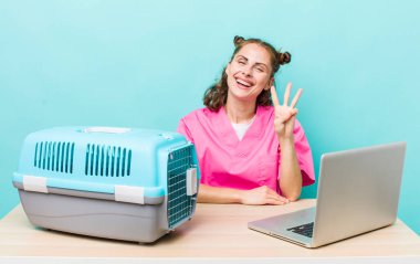 Genç, güzel bir bayan gülümsüyor ve arkadaş canlısı görünüyor, üç numarayı gösteriyor. Veterinerlik kavramı