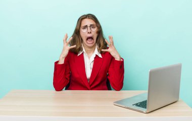 Genç ve güzel bir kadın ellerini havaya kaldırarak çığlık atıyor. iş kavramı