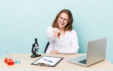 Genç ve güzel bir kadın kamerayı işaret ederek seni seçiyor. Mikroskop konseptine sahip bilim adamı