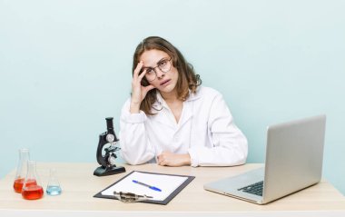 Genç ve güzel bir kadın sıkıcı, bıkkın ve uykulu hissediyor. Mikroskop konseptine sahip bilim adamı