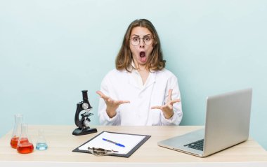 Genç ve güzel bir kadın şok olmuş ve şaşırmış hissediyor. Mikroskop konseptine sahip bilim adamı