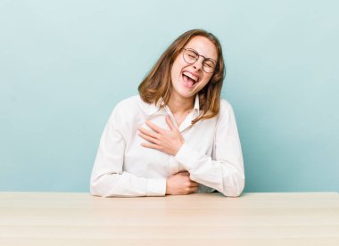 young pretty woman  laughing out loud at some hilarious joke. desk and business concept