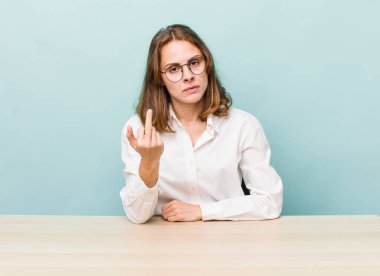 young pretty woman  feeling angry, annoyed, rebellious and aggressive. desk and business concept