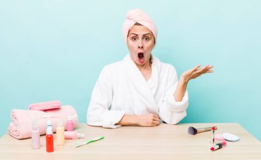 Genç ve güzel bir kadın şaşırmış ve şok olmuş görünüyor. Çenesi düşmüş ve elinde bir nesne tutuyor. uydurma konsepti