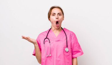 Genç ve güzel bir kadın şaşırmış ve şok olmuş görünüyor. Çenesi düşmüş ve elinde bir nesne tutuyor. Veterinerlik kavramı