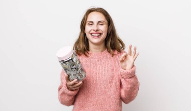 Genç ve güzel bir kadın kendini mutlu hissediyor. Onayını iyi bir hareketle gösteriyor. kaydetme kavramı