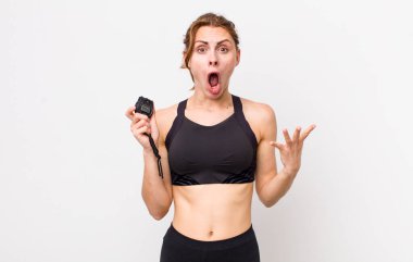 Genç ve güzel bir kadın şok olmuş ve şaşırmış hissediyor. fitness konsepti ve kronometre