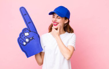 Genç ve güzel bir kadın, mutlu ve kendinden emin bir ifadeyle gülümsüyor, elleri çenesinde. Bir numaralı hayran konsepti