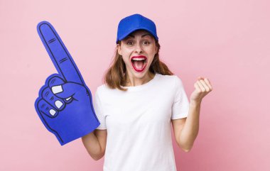 Genç ve güzel bir kadın şokta, gülüyor ve başarıyı kutluyor. Bir numaralı hayran konsepti