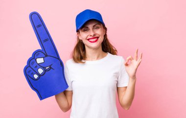 Genç ve güzel bir kadın kendini mutlu hissediyor. Onayını iyi bir hareketle gösteriyor. Bir numaralı hayran konsepti