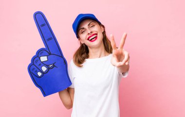 Gülümseyen ve mutlu görünen genç, güzel bir kadın zafer ya da huzur simgesi. Bir numaralı hayran konsepti